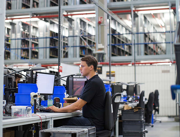 Man Checks Computer In Warehouse